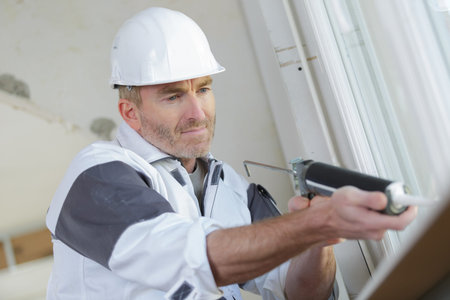 builder installing silicone in a window seal