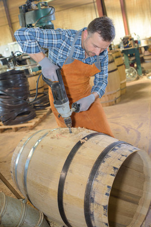a male cooper drilling a barrelの写真素材