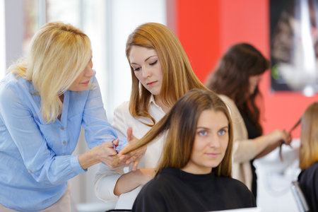 a teacher helping student hairdressersの写真素材