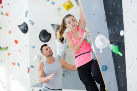 nervous lady on indoor climbing wallの写真素材