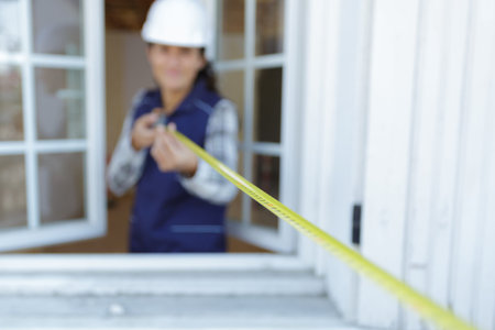 extended tape measure held by professional woman