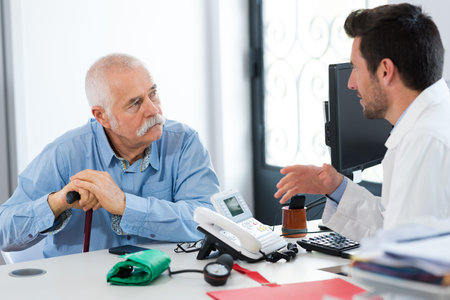 doctor checking old man patient arterial blood pressure