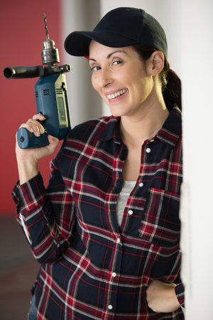 happy woman holding a drillの写真素材