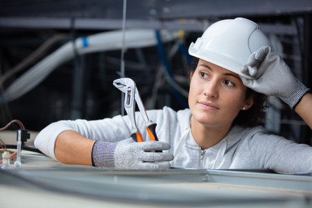 female engineer in rooftop holding pliersの写真素材