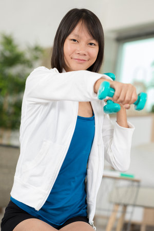 girl exercising with dumbbells indoorsの写真素材