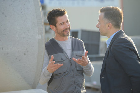customer standing with construction worker outsideの写真素材
