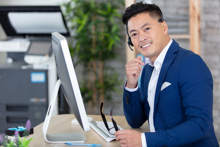 smiling businessman wearing a headset at the officeの写真素材