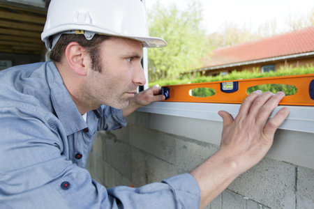a happy worker checks the level of a window