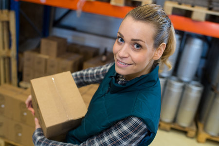 female carrying boxes in warehouseの写真素材