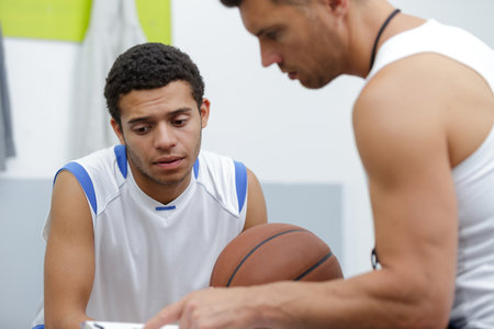basketball coach and player looking at scheduleの写真素材