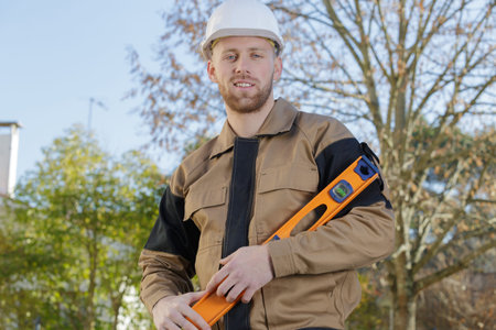 male contractor with level outdoors