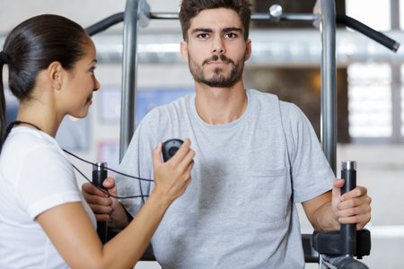 young man and his personal trainer discussing trainingの写真素材