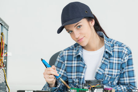 female testing electronic equipment in service centerの写真素材