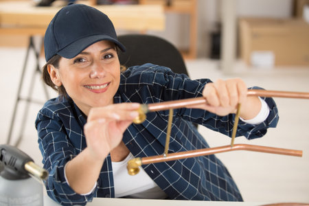 happy female worker using copper pipe
