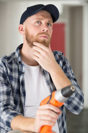 builder with electric drill thinkingの写真素材