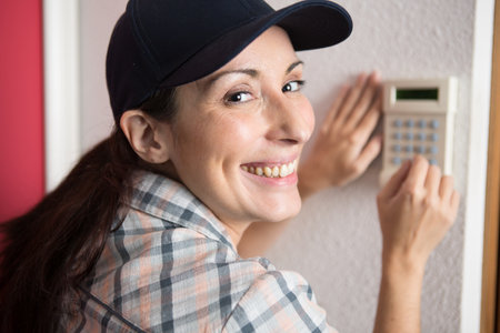 female cctv installer checking security alarmの写真素材