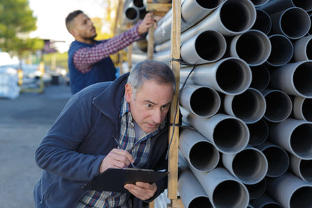 manager checking stacks of black pvc plastic pipeの写真素材