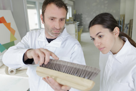 tutor showing student a wallpapering brushの写真素材