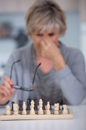 senior woman playing chess at homeの写真素材