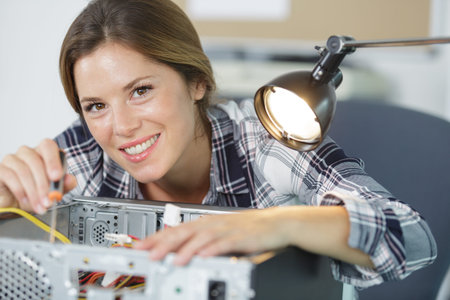 young woman fixing a desktop computer