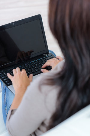 a woman using laptop indoorsの写真素材