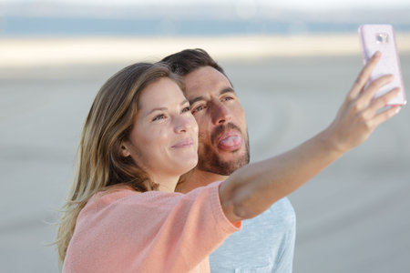 beautiful couple taking a selfie photo on white backgroundの写真素材
