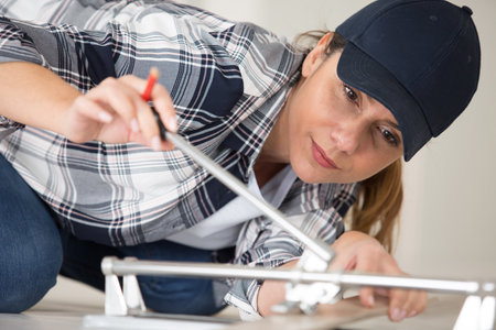 female worker is assembling metal-plastic window in workshopの写真素材