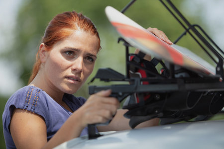 woman preparing the roof rack for a ski vacationの写真素材