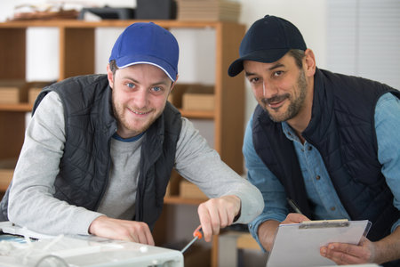 two ac technicians repairing an industrial compressor unitの写真素材