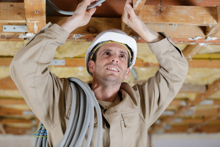 a male builder is doing cable trunking