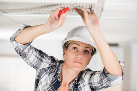 engineer woman installing ventilation ceilingの写真素材