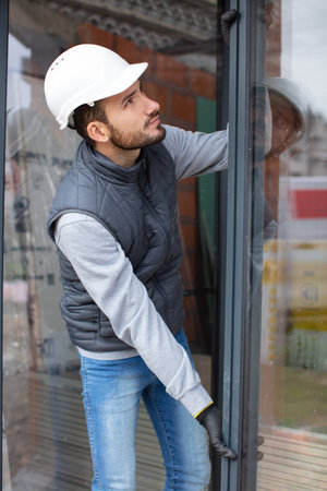 handsome young man installing bay window in a new house