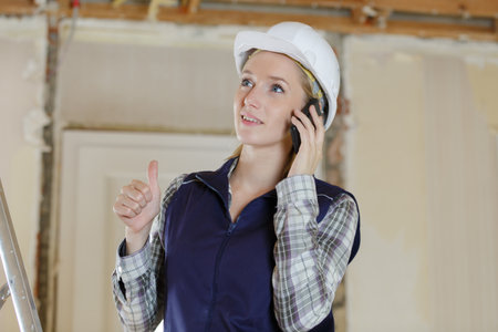 beautiful builder talking by phone at construction siteの写真素材