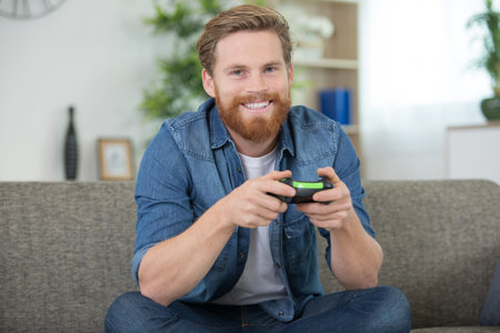 portrait of handsome attractive bearded funny cheerful playing videogame