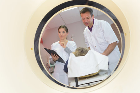 patient undergoing mri scan assisted by doctorsの写真素材