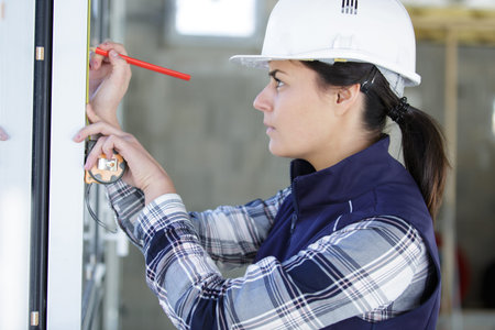 female decorator measuring window frame