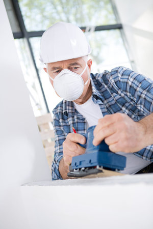 man sanding the wall
