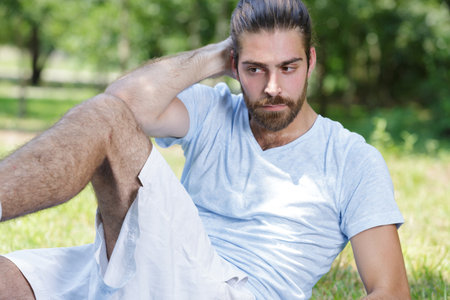 young man doing cross leg crunchesの写真素材