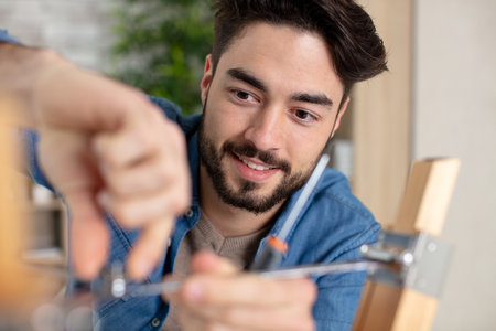 happy man fixing screw of the window limitの写真素材