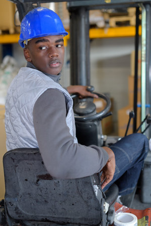 man on forklift loading boxes at warehouse