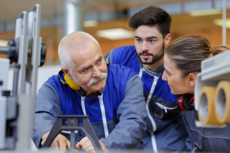 portrait of engineers and apprentices in busy factory