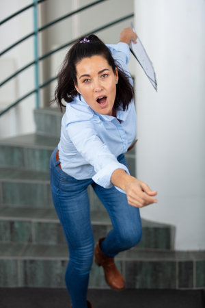 woman falling down from stairs in modern officeの写真素材