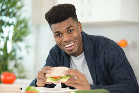 young man eating a sandwichの写真素材