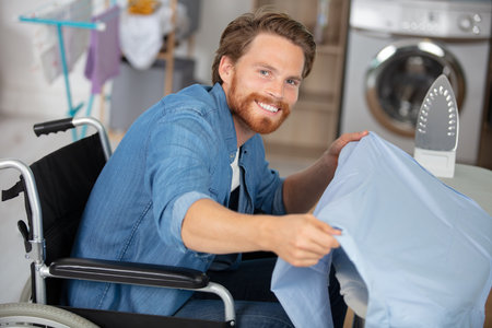 horizontal view of a disabled man during ironingの写真素材