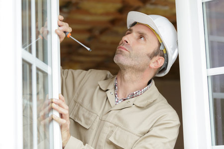 repairman fixing window frame in room