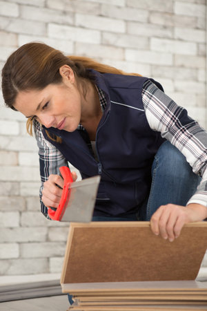 woman using backsaw to cut through woodの写真素材