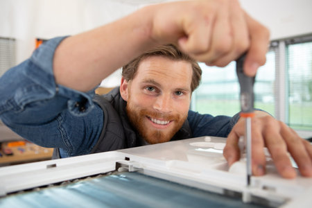 a happy worker screwing a window