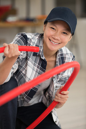 female builder carrying red pipeの写真素材