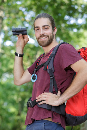 happy man with binoculars in the forest