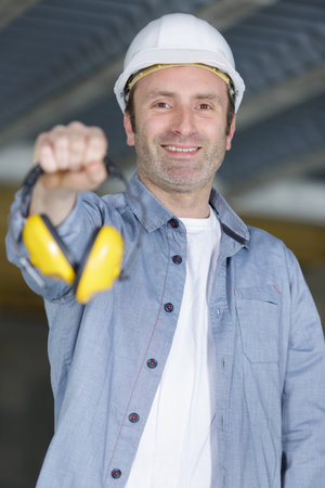 a man holding protective headphones
